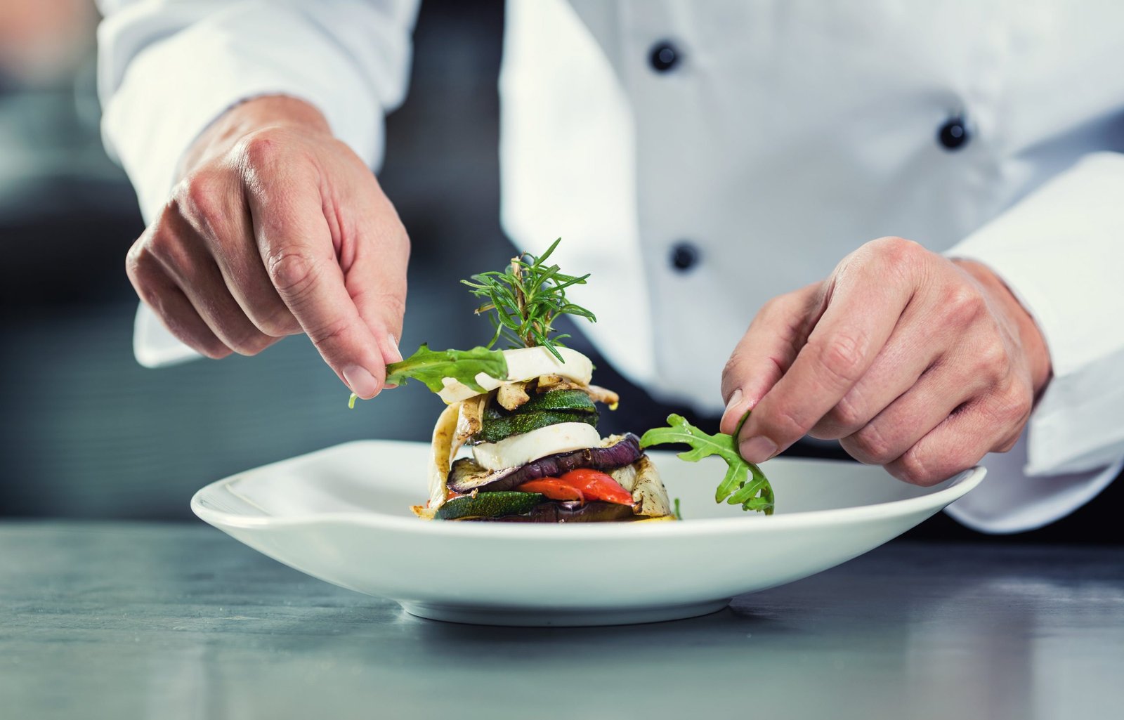Chef emplatando en una cocina profesional, contexto de formación gastronómica